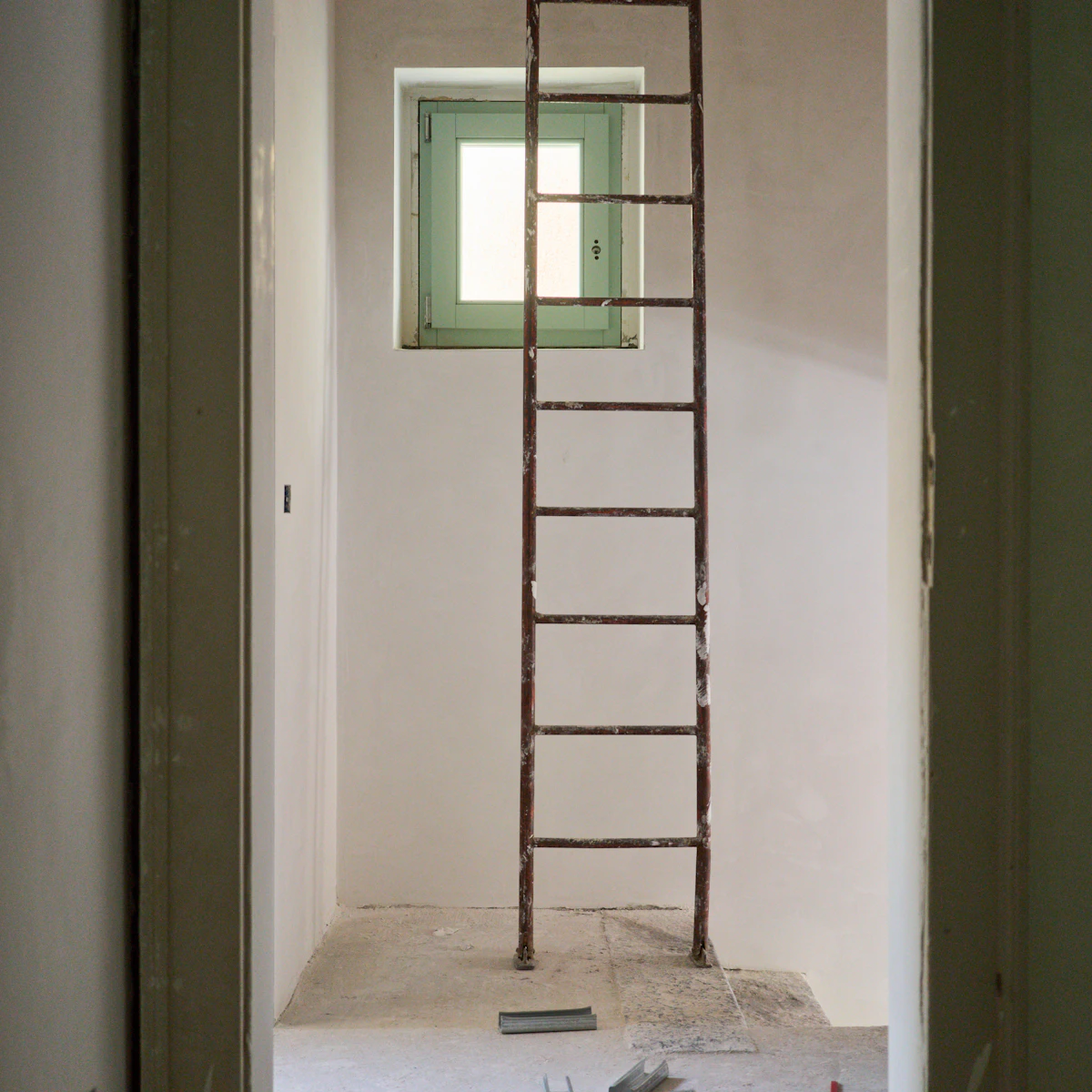 Freshly renovated room with a ladder and construction dust waiting for post-construction cleaning